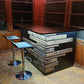 Rustic home bar crafted from reclaimed wood, featuring distressed finishes and ample storage shelves for bottles and glassware, creating a cozy and inviting atmosphere for entertaining guests