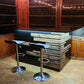 Rustic home bar crafted from reclaimed wood, featuring distressed finishes and ample storage shelves for bottles and glassware, creating a cozy and inviting atmosphere for entertaining guests