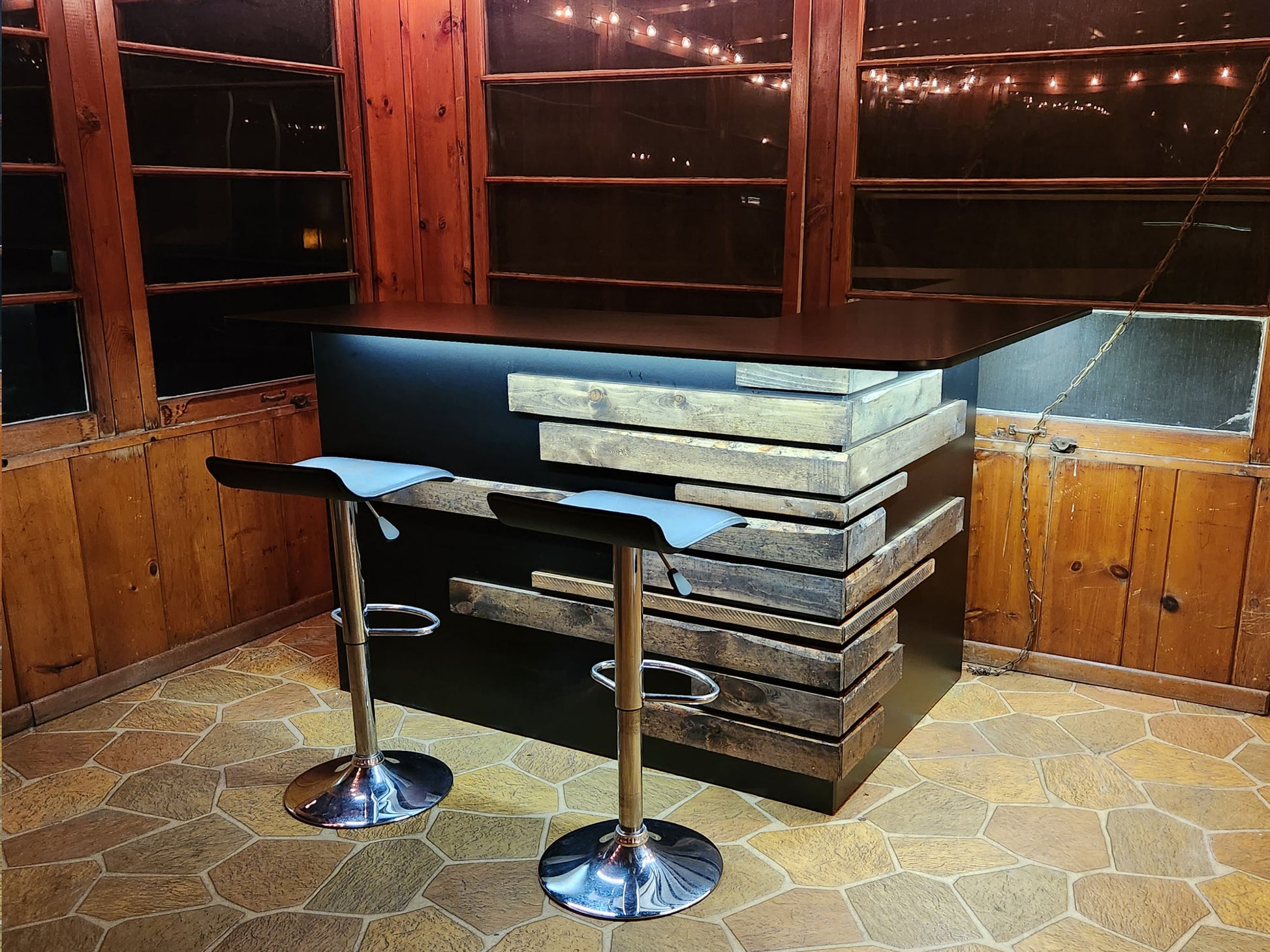 Rustic home bar crafted from reclaimed wood, featuring distressed finishes and ample storage shelves for bottles and glassware, creating a cozy and inviting atmosphere for entertaining guests
