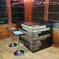 Rustic home bar crafted from reclaimed wood, featuring distressed finishes and ample storage shelves for bottles and glassware, creating a cozy and inviting atmosphere for entertaining guests